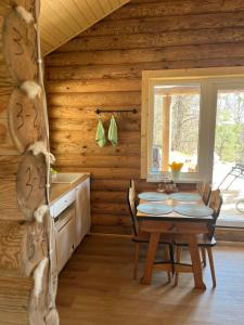 a dining room with a table and a window at Miško sodyba in Gedvainiai