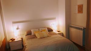 a bedroom with a bed with two lamps on it at El Rincón del Ángel in Jaca