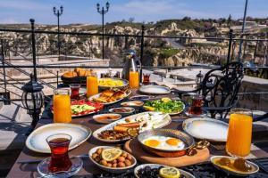 a table with plates of food on top of a balcony at Aurelia Cave Cappadocia - Special Class in Nevşehir