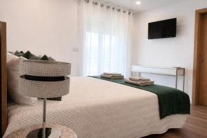 a bedroom with a bed with a television on the wall at Panorama Douro House in Armamar