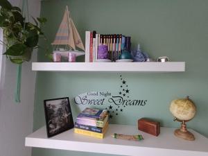 a shelf with books and stars on a wall at Quarto Casa na Praia in Porches