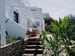 a white house with stairs leading to a patio at Louis Studios Armeos in Masouri