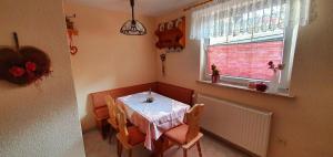a dining room with a table and a window at FEWO Aschbergblick in Klingenthal