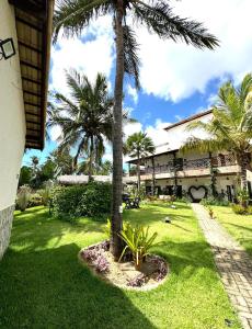 a palm tree in a yard next to a building at Pousada Varanda Amar - Icaraizinho de Amontada in Icaraí
