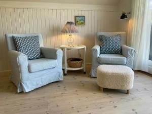 a room with two chairs and a table with a lamp at Charming House With A View Of The Sea in Båring