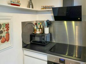 a kitchen with a counter top with a microwave at Charming House With A View Of The Sea in Båring