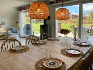 a dining room table with chairs and two lights at Charming House With A View Of The Sea in Båring +32 photos