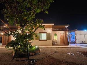 a house with a tree in front of it at night at เดอะมูนไลท์วิลล่าพะเยา in Phayao