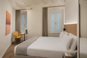 a hotel room with a bed and a table at AMIRA Ca' Argento Premium Apartments in Trieste Center in Trieste
