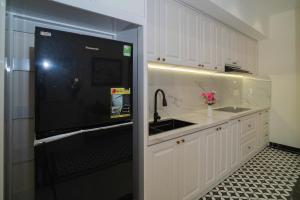 a kitchen with a sink and a black refrigerator at Maison Hin in Hoi An +53 photos