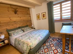 a bedroom with a bed and a wooden wall at B & B Chalet Plan in Strembo