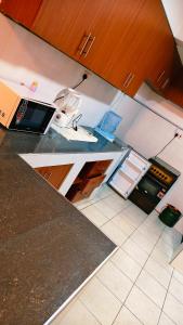 a kitchen with a black counter top and a refrigerator at Shima Complex in Nakuru