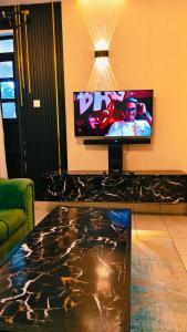 a living room with a flat screen tv and a table at Shima Complex in Nakuru