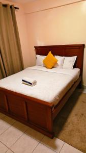 a bed with a book sitting on top of it at Shima Complex in Nakuru