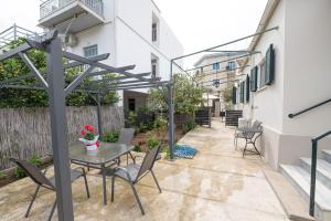 a patio with a table and chairs and a building at Sunny yard apartments in Poros