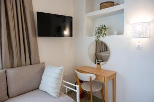 a living room with a couch and a table with a mirror at Sunny yard apartments in Poros