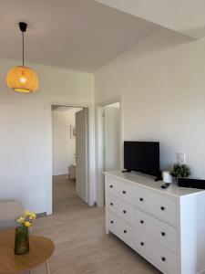 a living room with a white dresser with a tv on it at Maison Soleil II in Kastro Kyllini