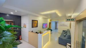 a waiting area in a hospital with a blue couch at Hotel Anantha Suites in Sitam Petta