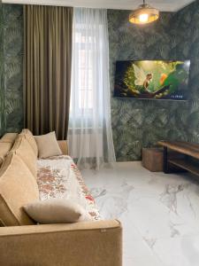 a living room with a couch and a tv on a wall at S-Van Cozy Home in Sevan