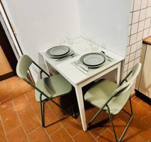 a white table with chairs and plates and wine glasses at Dolce Notte - Rustico a Gandria in Lugano