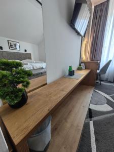 a living room with a wooden table and a bed at Motel Maks in Kiseljak