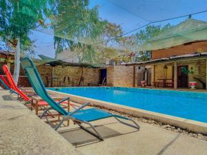 a pair of lawn chairs sitting next to a swimming pool at La Maison Chocolat in Nianing