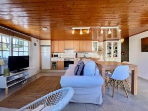 a living room with a white couch and a wooden ceiling at Casa La Finca in Vigo