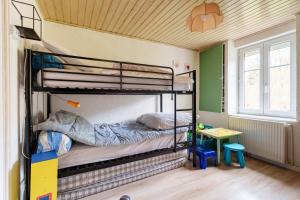 a bunk bed room with two bunk beds and a table at Gîte forestier du Moulin - 10 pers in Raon-sur-Plaine