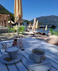 a wooden table with two cups of coffee on it at Risinium sun in Risan