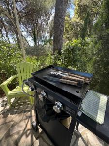 a grill and a chair on a patio at Appel du Luberon in Mérindol