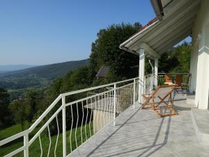 a balcony of a house with a table and chairs at Vineyard cottage SkyView in Semič