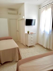 a bedroom with two beds and a tv on a wall at Casa Salento Diso in Diso