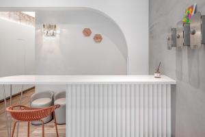 a kitchen with a white counter and two chairs at Wuyu in Tainan