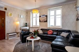 a living room with a black leather couch and a table at Apartamenty Boutique in Ustka