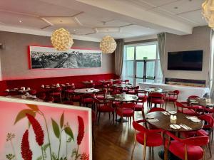 a restaurant with tables and red chairs and a tv at The Park Hotel in Liverpool