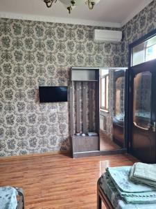 a room with a tv and a wall with wallpaper at сой333 in Navoi