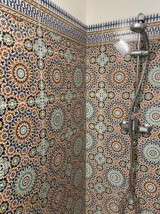 a shower in a bathroom with a tile wall at Le Dauphiné in Châtillon-en-Diois +94 photos