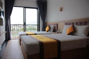 a hotel room with two beds and a large window at A59 Memory Hotel Tuan Chau in Ha Long