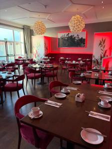 a restaurant with tables and chairs and red walls at The Park Hotel in Liverpool