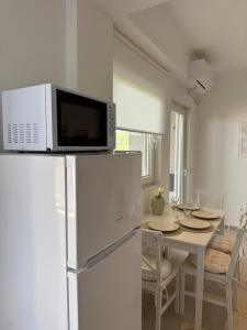 a kitchen with a microwave on top of a refrigerator at Maison Soleil II in Kastro Kyllini +2 photos