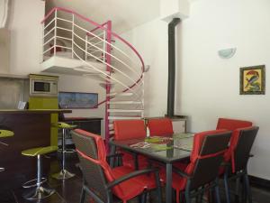 a dining room with a table and red chairs at Gîte de Roques in Serres-sur-Arget