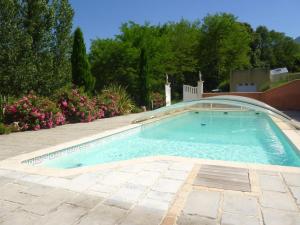 a swimming pool in a yard with flowers at Gîte de Roques in Serres-sur-Arget