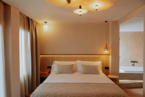 ein Schlafzimmer mit einem großen Bett und einer Badewanne in der Unterkunft Hotel Meridional in Guardamar del Segura