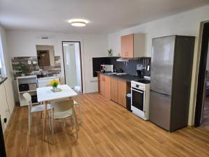 a kitchen with a table and a refrigerator at Apartmány Mácháč in Doksy