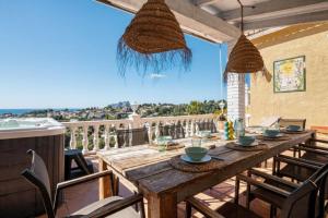 a wooden table on a balcony with a view of the ocean at Robis Moraira in Benissa