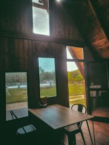 a table and chairs in a room with windows at La Empinada in Bialet Massé
