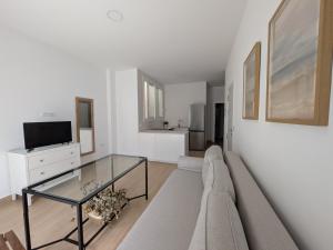 a living room with a couch and a glass table at Apartamento Calle Bolsa in Sanlúcar de Barrameda