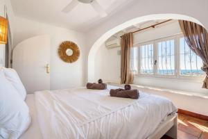 a bedroom with a large white bed with two towels on it at Robis Moraira in Benissa +27 photos
