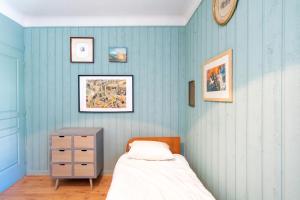 a bedroom with blue walls and a bed and a dresser at Maison de charme a Bayonne in Bayonne