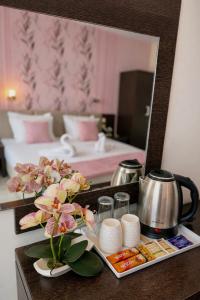 a table with flowers and a mirror in a hotel room at Hotel Ancora Beach in Primorsko